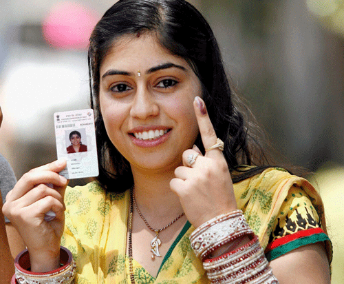 A woman shows her inked finger after casting her vote at a polling station in Mohali on Wednesday. PTI Photo