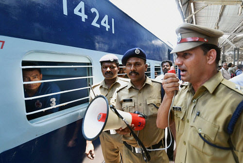 A security person makes an announcement at a railway platform where a train was ripped by two blasts at Chennai railway station on Thursday. PTI Photo