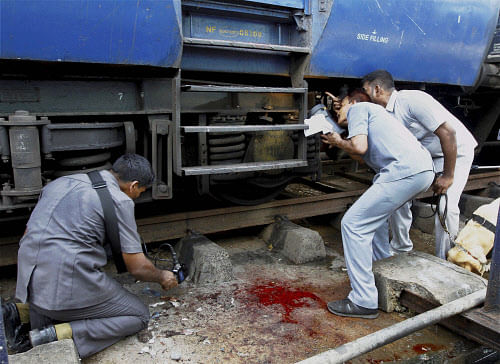 Blood lies splattered as bomb squad personnel inspect a train that was ripped by two blasts at the railway station in Chennai on Thursday. PTI Photo
