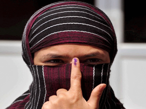 A muslim woman shows her ink marked finger after casting vote for 8th phase of Loksabha Election on Wednesday. PTI Photo