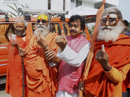 Sankaracharya Swami Vasudevanand Saraswati and other sadhus show their inked fingers after casting their votes for Lok Sabha polls at a polling station in Allahabad on Wednesday. PTI Photo