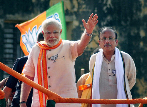 BJP PM candidate Narendra Modi waves during an election road show in Varanasi. PTI Image