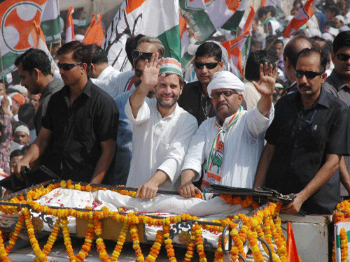 Rahul Gandhi waves to the crowd at a road show with party candidate Ajay Rai in Varanasi.PTI Photo