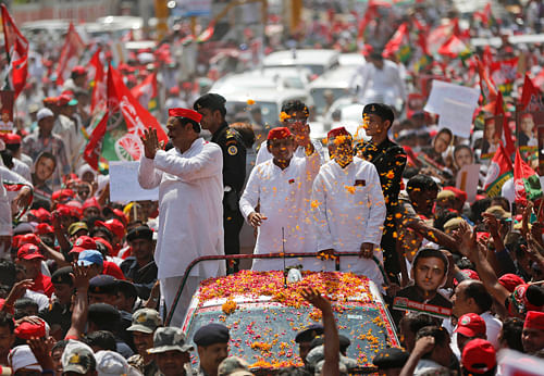 Uttar Pradesh state Chief Minister Akhilesh Yadav, center, waves at supporters during an election campaign rally in Varanasi. The Commission also rejected any bias in allowing roadshow by Rahul Gandhi and UP Chief Minister Akhilesh Yadav but denying permission for Narendra Modi to address a public meeting in his constituency from a venue of BJP's choice on Wednesday in a communally sensitive area. AP