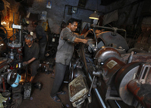 Men work inside a car spare parts manufacturing workshop in Kolkata. Reuters.