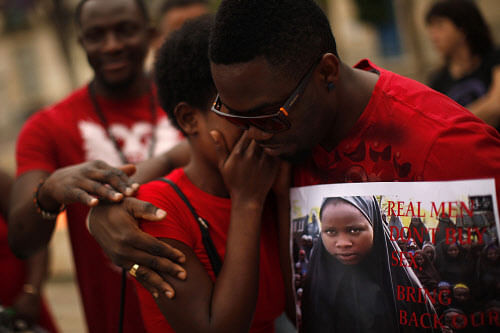 A Nigerian woman is comforted by a man as they take part in a protest, called by Malaga's Nigerian women Association, for the release of the abducted secondary school girls from the remote village of Chibok in Nigeria, at La Merced square in Malaga, southern Spain May 13, 2014.The leader of the Nigerian Islamist rebel group Boko Haram has offered to release more than 200 schoolgirls abducted by his fighters last month in exchange for its members being held in detention, according to a video posted on YouTube on Monday. REUTERS