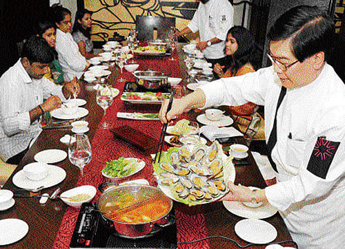 A simmering metal pot consisting of several varieties of stew from East Asia will be kept on the centre of the table and guests will be able to choose from various ingredients like thinly sliced meat, sea food and vegetables. DH photo