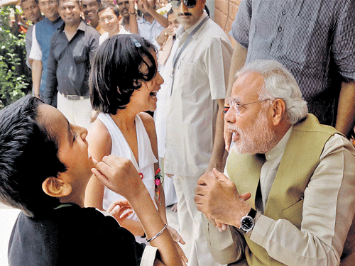 A victorious Narendra Modi interacts with kids during a meeting with his mother Hiraba at her home in Gandhinagar as election results showed a landslide win for BJP led by him. Silencing his critics by getting the highest numbers for his party ever, BJP's prime minister designate Narendra Modi, in his maiden address to the nation after his victory, said he would be 'mazdoor number one of the country'. PTI photo