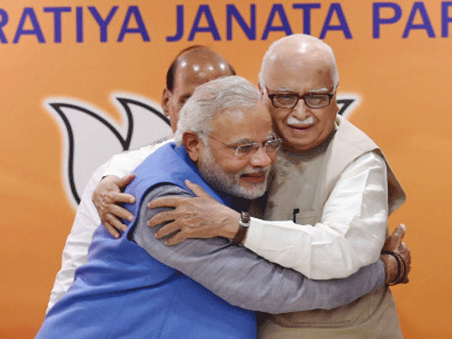 Bharatiya Janata Party leader and the next Prime Minister Narendra Modi with senior party leader L K Advani during the party's parliamentary board meeting in New Delhi on Saturday. PTI Photo