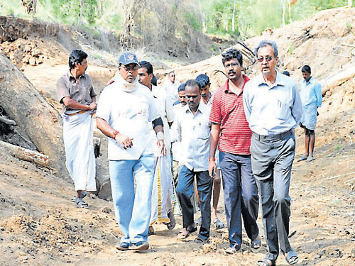 Chamarajanagar thasildar Shivanna inspects the banks of Suvarnavathi river, near Kooldur of Chamarajanagar district, where illegal sand mining has continued unabated, on Saturday. DH photo