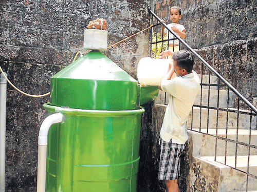 William Colaco adds waste to the domestic bio-gas tank at his house in Shaktinagar. DH photo