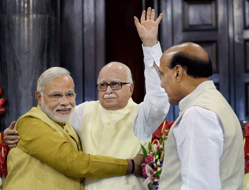 Prime Minister-elect Narendra Modi hugs an emotional LK Advani as Rajnath Singh looks on during the BJP parliamentary party meeting at the Central Hall of Parliament in New Delhi on Tuesday. PTI Photo