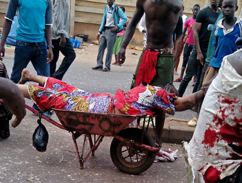 n injured woman is carried after bombs exploded at a bus terminal and market in Jos, Nigeria, Tuesday, May 20, 2014. Two car bombs exploded at a bustling bus terminal and market in Nigeria's central city of Jos on Tuesday, and witnesses said dozens of people were killed. No one immediately claimed responsibility for the twin car bombs, but they bore the hallmarks of Boko Haram, an Islamic extremist group. AP Photo