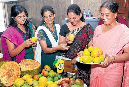 Women take a look at mangoes and jackfruits on display at a press conference in Bangalore on Wednesday. DH photo