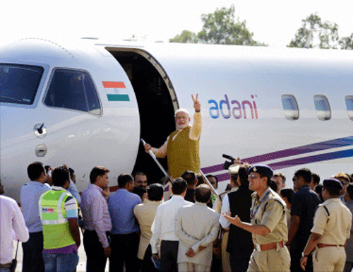 Prime Minister-designate Narendra Modi waves while boarding a flight for Delhi at the airport in Ahmedabad on Thursday. PTI Photo