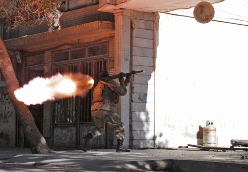 An Afghanistan National Army (ANA) soldier fires his weapon at the site of a clash between insurgents and security forces on the Indian Consulate in Herat, Afghanistan, Friday, May 23, 2014. Gunmen armed with machine guns and rocket-propelled grenades attacked the Indian Consulate in western Afghanistan's Herat province Friday, an assault that injured no diplomatic staff, police said. Indian officials said there had been a threat against its diplomats in Afghanistan, but gave no other details. AP