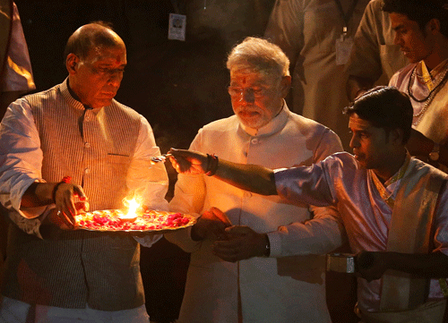 Narendra Modi, center, and BJP President Rajnath Singh, left, perform evening rituals with a Hindu priest on the banks of the River Ganges in Varanasi. Veteran artistes from the Benaras gharana are now looking up to Narendra Modi for revival of the glorious musical heritage of the ancient city. AP