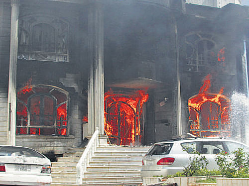 A house burns at the site of a clash between insurgents and security forces at the Indian Consulate in Herat, Afghanistan, on Friday. AP