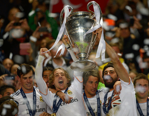 Real Madrid players lift the Champion League trophy after winning the Champions League final soccer match between Atletico Madrid and Real Madrid in Lisbon, Portugal, Saturday, May 24, 2014. AP