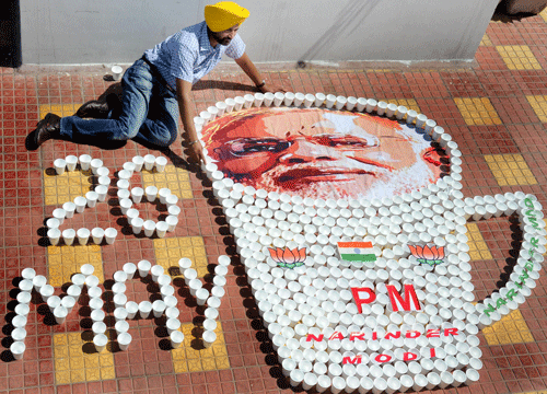 A miniature artist creates a picture of Prime Minister-designate Narendra Modi with glasses used for serving tea to congratulate him ahead of his swearing-in ceremony, in Amritsar on Saturday. PTI Photo