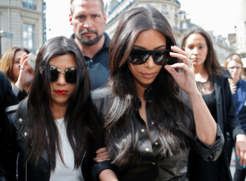 TV personality Kim Kardashian (R) and her sister Kourtney walk in the street as they visit fashion shops in Paris May 22, 2014. U.S. television personality Kim Kardashian and rapper Kanye West will celebrate their wedding in Florence over the weekend, an official from the mayor's office confirmed last Friday. REUTERS