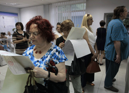 Ukrainians read their ballot papers at a polling station in Kiev, Ukraine, Sunday, May 25, 2014 AP photo