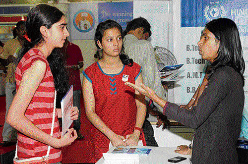 Students gather information from a representative of an institute at the education fair. dh photo