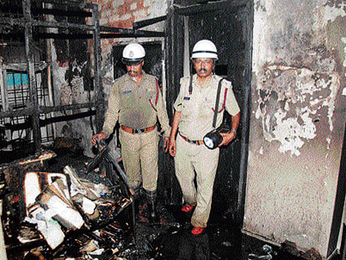 Tragedy strikes: Fire personnel inspect the spot where fire broke out and killed two persons at an advocate's office at Gandhinagar in the City on Sunday. DH Photo