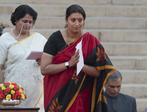 Smriti Irani greets the audience after she takes the oath of office at the presidential palace in New Delhi, AP photo