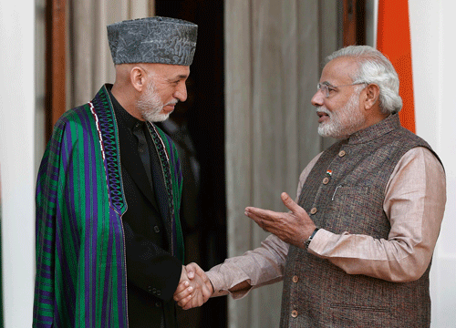 Prime Minister Narendra Modi (R) shakes hands with Afghanistan's President Hamid Karzai before start of their meeting in New Delhi May 27, 2014. Modi was sworn in as India's prime minister in an elaborate ceremony at New Delhi's resplendent presidential palace on Monday, after a sweeping election victory that ended two terms of rule by the Nehru-Gandhi dynasty. REUTERS