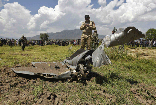 A police officer near the debris of an IAF MiG-21 jet at a field near Awantipora, south of Srinagar on Tuesday. Reuters photo