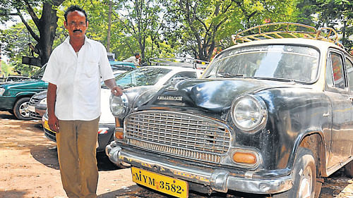 Akram, with his Ambassador car at the taxi stand opposite KSRTC sub-urban bus stand on Bangalore-Nilgiri road in Mysore. DH PHOTO