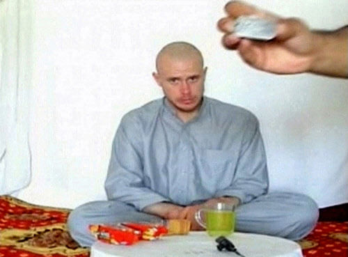 U.S. Army Private Bowe Bergdahl watches as one of his captors display his identity tag to the camera at an unknown location in Afghanistan in this July 19, 2009 file still image taken from video. Bergdahl, held for nearly five years by the Taliban after being captured in Afghanistan, has been released and is now in U.S. custody after years of on and off negotiations, U.S. officials said on May 31, 2014. REUTERS