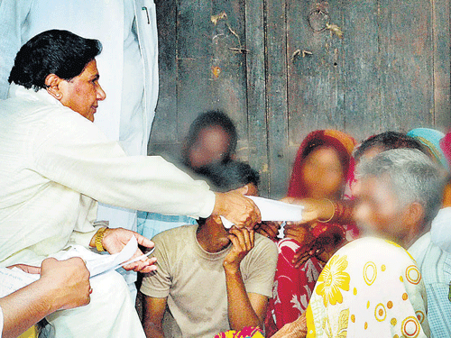 BSP supremo Mayawati interacts with the family members of two sisters who were gang-raped and hanged from a tree at Katra Shahadatganj village, in Badaun district on Sunday. PTI