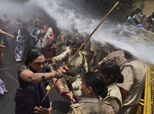 A left, one among the protestors demonstrating outside the office of Uttar Pradesh state chief minister Akhilesh Yadav, demanding that he crack down on an increasing number of rape and other attacks on women and girls, scuffles with police in Lucknow, India, Monday, June 2, 2014. Police used water cannons to disperse hundreds of women who were protesting Monday against a rise in violence against women in the northern Indian state where two teenagers were gang-raped last week and later found hanging from a tree. AP photo