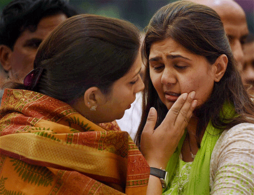 HRD Minister Smriti Irani consoles the daughter of Union minister Gopinath Munde after paying respect to his mortal remains at the BJP headquarters in New Delhi on Tuesday. Munde died on Tuesday morning in a road accident in New Delhi. PTI Photo