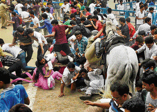 mayhem: People run for cover as mounted policemen resort to lathi-charge outside the Eden Gardens on Tuesday. pti