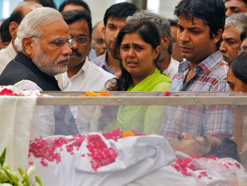 Prime Minister Narendra Modi (L) looks at the casket of Rural Development Minister Gopinath Munde, next to Munde's daughter Pankaja Munde Palve (C), at Bharatiya Janata Party (BJP) headquarters in New Delhi June 3, 2014. Munde died on Tuesday after a road collision in New Delhi, depriving Modi of a key ally just eight days after coming to office with a mandate to revitalise a stalled economy. REUTERS