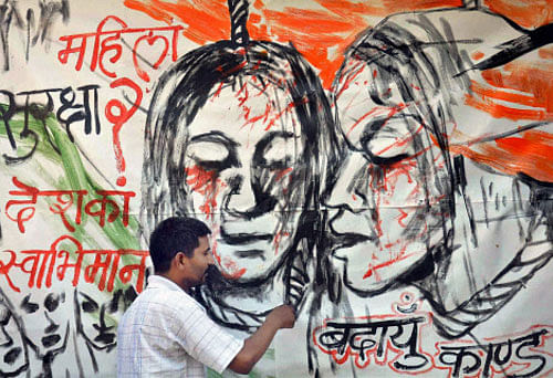 In the wake of recent rape case in Badaun, an artist draws a painting raising issues of women safety, in Moradabad. PTI photo