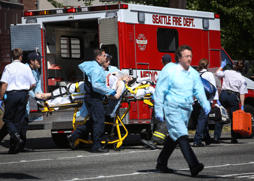 Medics wheel away a person shot at Seattle Pacific University on Thursday, June 5, 2014, in Seattle. A lone gunman armed with a shotgun opened fire Thursday in a building at a small Seattle university, fatally wounding one person before a student subdued him with pepper spray as he tried to reload, Seattle police said.  AP