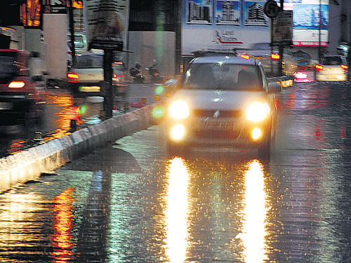 A car wades through a street water-logged by torrential  downpur in Mangalore on Sunday. DH Photo