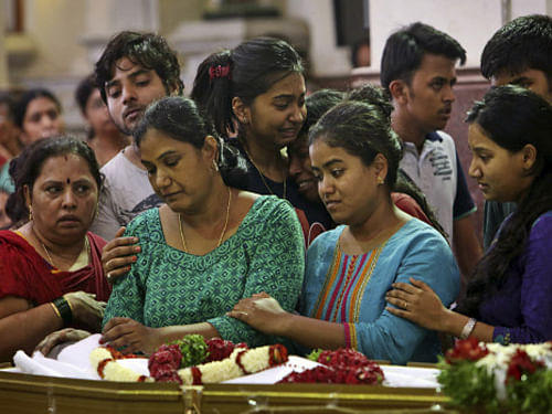 Relatives and friends, including mother Nirmala (C) of student Devasish Bose, who drowned after water was released from a dam in Himachal Pradesh, mourn around his coffin during a funeral mass at Saint Joseph Cathedral in Hyderabad. AP