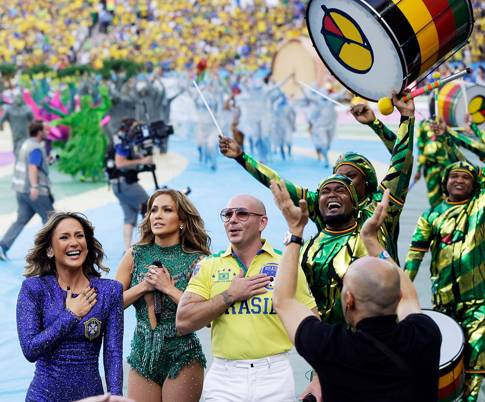 From left, Brazilian singer Claudia Leitte, US singer Jennifer Lopez and rapper Pitbull leave after performing during the opening ceremony before the group A World Cup soccer match between Brazil and Croatia, the opening game of the tournament, in the Itaquerao Stadium in Sao Paulo, Brazil, Thursday, June 12, 2014. (AP Photo)
