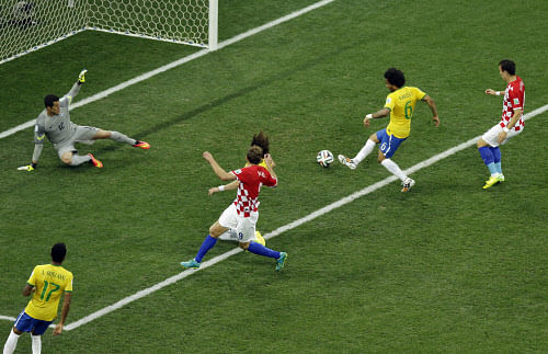Brazil's Marcelo, right, scores an own goal past Brazil's goalkeeper Julio Cesar during the group A World Cup soccer match between Brazil and Croatia, the opening game of the tournament, in the Itaquerao Stadium in Sao Paulo, Brazil, Thursday, June 12, 2014. (AP Photo)