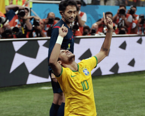 Assistant referee Nagi Toshiyuki from Japan watches as Brazil's Neymar celebrates his second goal on a penalty kick during the group A World Cup soccer match between Brazil and Croatia, the opening game of the tournament, in the Itaquerao Stadium in Sao Paulo. AP photo