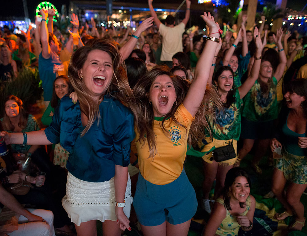 Soccer fans celebrate the second goal scored by Brazil striker Neymar, during a live broadcast at a World Cup viewing party at the Jockey Club, in Rio de Janeiro, Brazil, Thursday, June 12, 2014. After taking the early lead in the opening match of the international soccer tournament, Croatia fell 3-1 to the five-time champion Brazil. (AP Photo