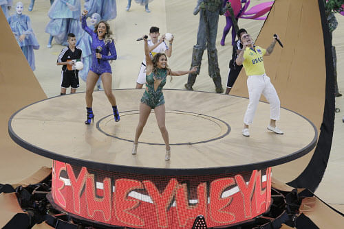 Brazilian singer Claudia Leitte, left, US singer Jennifer Lopez and rapper Pitbull perform during the opening ceremony ahead of the group A World Cup soccer match between Brazil and Croatia, the opening game of the tournament, in the Itaquerao Stadium in Sao Paulo, Brazil, Thursday, June 12, 2014. (AP Photo)