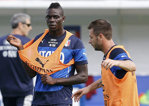 Italy's national soccer players Mario Balotelli (L) looks at his team mate Antonio Cassano during a training session ahead of the 2014 World Cup at the Portobello training center in Mangaratiba June 11, 2014. REUTERS