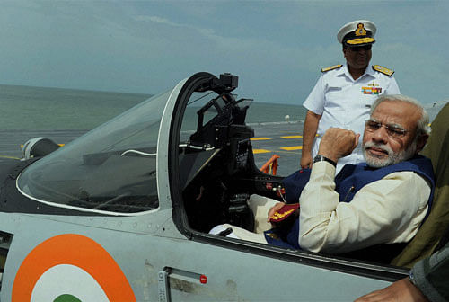 Prime Minister Narendra Modi sits in the cockpit of Mig 29 on the deck of the newly dedicated India's largest warship INS Vikramaditya,off the coast of Goa on Saturday. PTI Photo