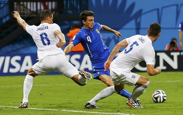 Italy's Matteo Darmian (C) fights for the ball with England's Phil Jagielka (L) and Gary Cahill during their 2014 World Cup Group D soccer match at the Amazonia arena in Manaus June 14, 2014.  Reuters